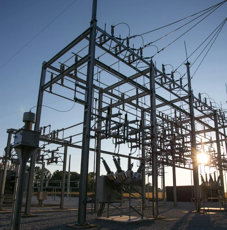 A Large Electrical Substation Silhouetted Against A Vibrant Sunset Sky