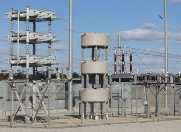 A large electrical substation featuring multiple towering structures and extensive electrical equipment