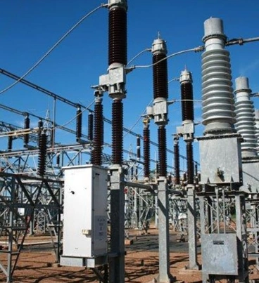 A large array of electrical equipment set up in an open field under a clear blue sky